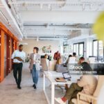 Group of professionals collaborating in a bright, modern office space designed for co-working and teamwork.