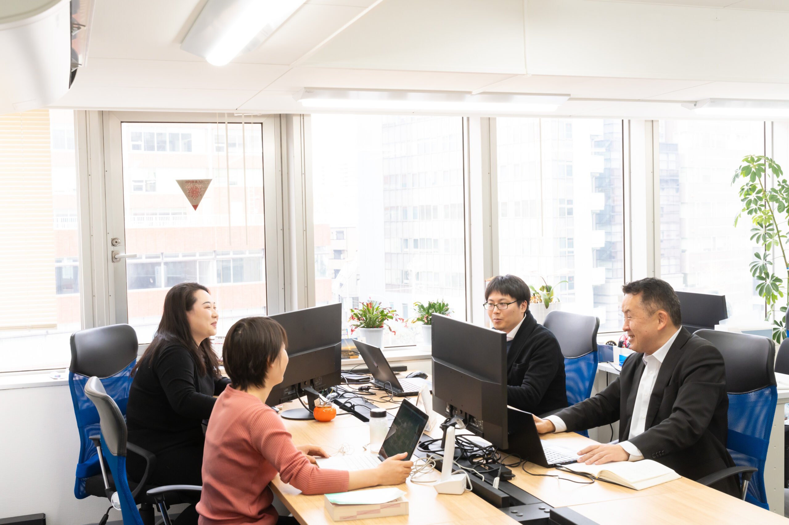 明るいオフィスでミーティングするチーム